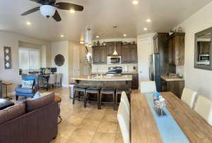 Tiled dining space with ceiling fan and sink