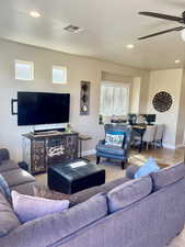 Tiled living room with plenty of natural light and ceiling fan