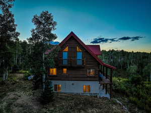 Back house at dusk featuring a balcony