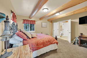 Carpeted bedroom with beam ceiling