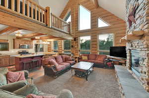 Living room with a fireplace, beam ceiling, high vaulted ceiling, and rustic walls