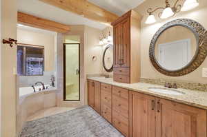 Bathroom featuring beam ceiling, separate shower and tub, and vanity