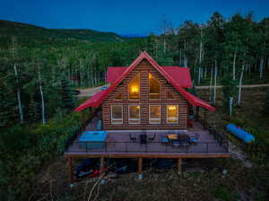 Back house at night featuring an outdoor living space and a deck