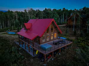 Back house at dusk featuring a deck