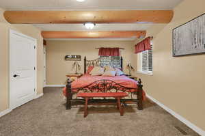 Bedroom featuring beam ceiling and carpet floors