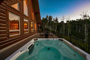 Pool at dusk with a hot tub