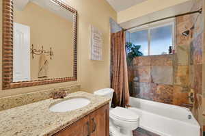 Full bathroom with vanity, shower / tub combo, and toilet