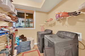 Laundry area featuring washer and dryer and light tile patterned floors