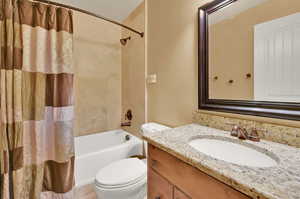 Full bathroom featuring toilet, vanity, and shower / tub combo