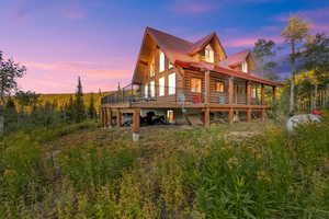 Back house at dusk with a wooden deck