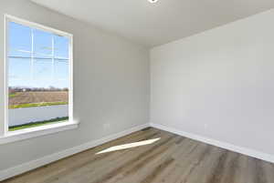 Empty room with light wood-style flooring and baseboards