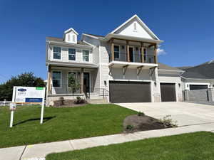 View of front of property with a front yard, covered porch, driveway, a garage, and stone siding