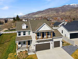 View of front facade with a shingled roof, covered porch, and concrete driveway