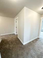 Spare room with a textured ceiling and carpet floors