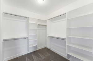 Walk in closet featuring dark carpet