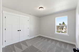 Unfurnished bedroom with carpet and a closet