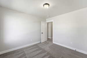 Spare room featuring baseboards and light colored carpet