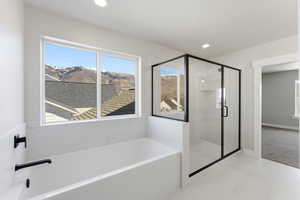 Bathroom featuring a shower stall, a garden tub, a mountain view, and recessed lighting