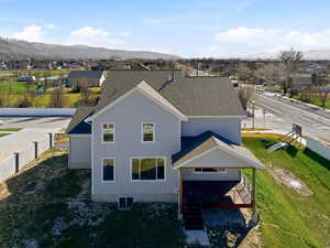 View of front of home with a mountain view, a residential view, and a shingled roof