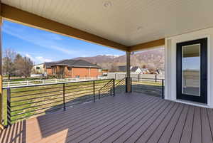 Deck with a mountain view, a residential view, and a yard