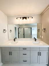 Full bath featuring double vanity and a stall shower