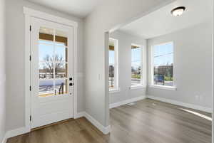Doorway featuring baseboards and wood finished floors