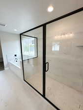 Full bath with a bath, a marble finish shower, a textured ceiling, marble look tile flooring, and recessed lighting