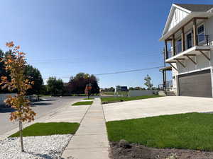 View of yard featuring driveway, an attached garage, and a porch