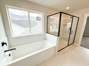 Full bathroom with a garden tub, a shower stall, recessed lighting, and marble look tiles