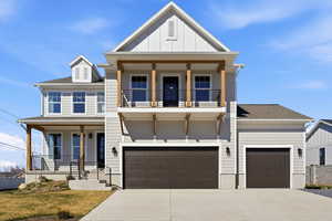 View of front of home featuring covered porch, driveway, board and batten siding, and a shingled roof