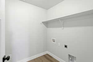 Laundry area featuring electric dryer hookup, light wood-style floors, and washer hookup
