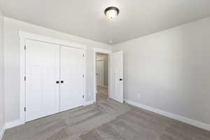 Unfurnished bedroom with carpet and a closet