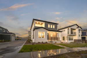 View of front facade featuring a garage and a yard