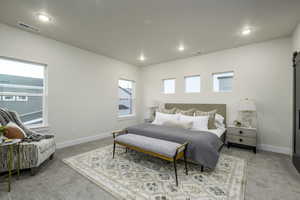 Carpeted bedroom with multiple windows