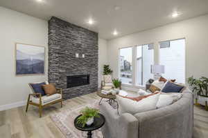 Living room featuring light hardwood / wood-style floors and a stone fireplace