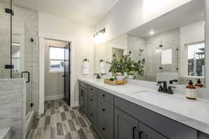 Bathroom featuring vanity, a textured ceiling, and a shower with door