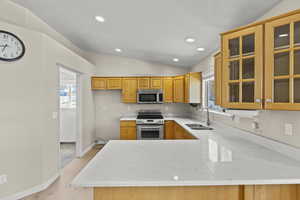 Kitchen featuring a sink, vaulted ceiling, stainless steel appliances, and a wealth of natural light