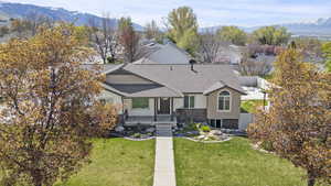 View of front of home featuring a front lawn, roof with shingles, a mountain view, and fence