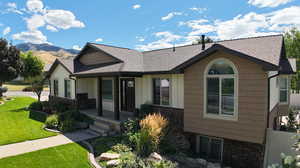 View of front of property with a mountain view and a front yard