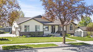 View of front of property with board and batten siding, fence, and a front yard