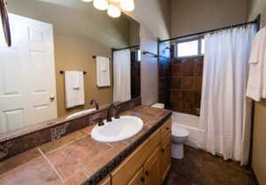 Full bathroom featuring tile patterned floors, toilet, shower / bathtub combination with curtain, and vanity