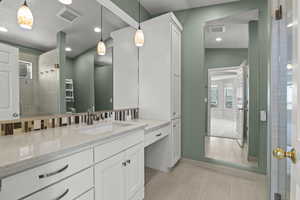 Bathroom with visible vents, recessed lighting, vanity, and tiled shower