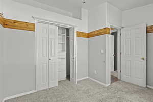 Unfurnished bedroom with carpet flooring, baseboards, and a closet