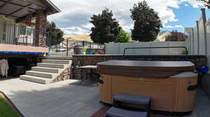 View of patio featuring a hot tub and a mountain view