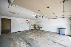 2 Garage featuring EVC station, extra storage, work bench, and a garage door opener