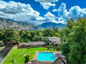 View of pool with a mountain view and a yard