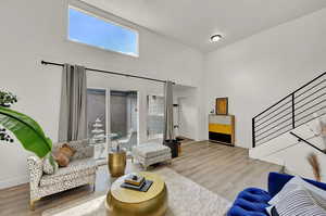 Living room with a vaulted ceiling and light wood-style floors