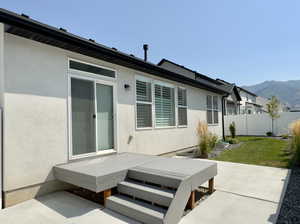 Rear view of house with a deck with mountain view and a yard