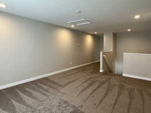 Carpeted empty room with a textured ceiling