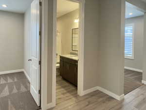 Bathroom featuring wood-type flooring, toilet, and vanity